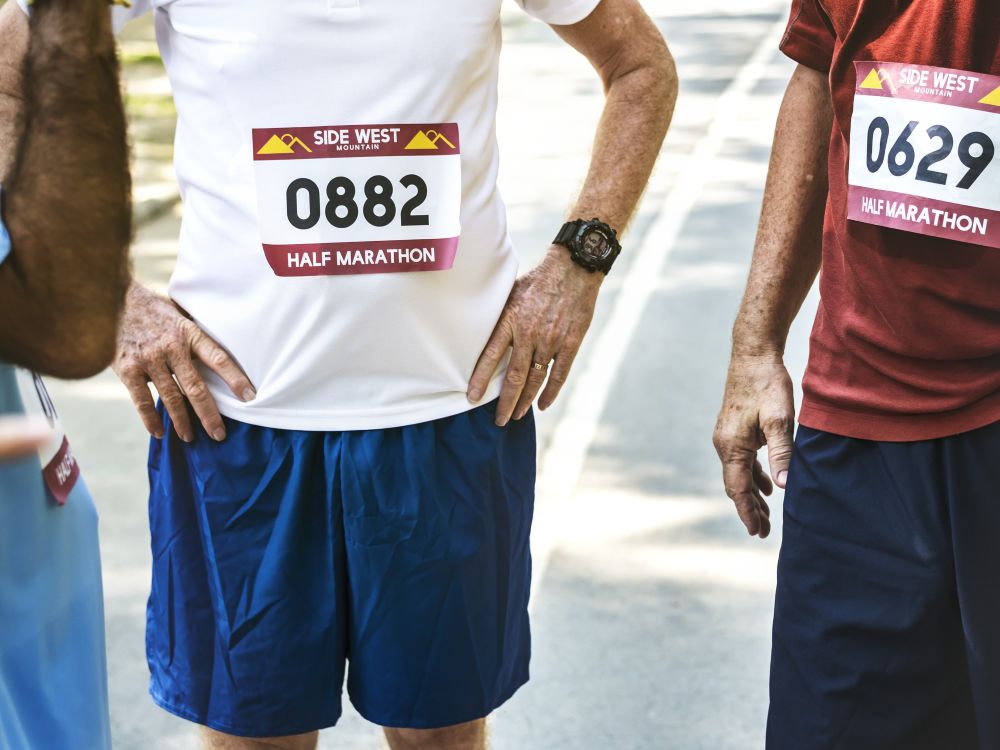 Consulta el Reglamento de la III Carrera por la Espondilitis Persona consultando el reglamento de la carrera en un dispositivo móvil.